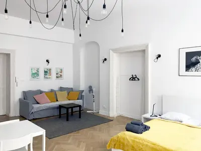 a white living room with a couch and a bed at Florianska Apartment in Kraków