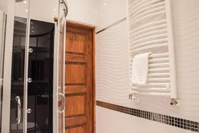 a bathroom with a shower and a wooden door at Apartment Nearto Old Town Na Ustroniu street in Kraków