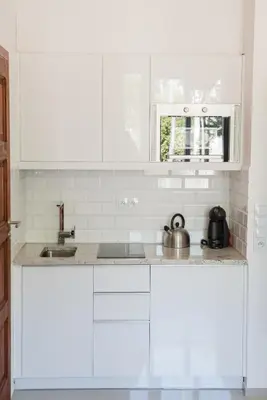 a white kitchen with white cabinets and a sink at Apartment Nearto Old Town Na Ustroniu street in Kraków