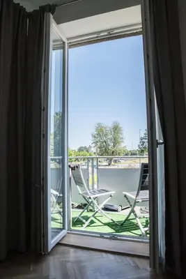 a sliding glass door leading to a balcony with a chair at Apartment Nearto Old Town Na Ustroniu street in Kraków