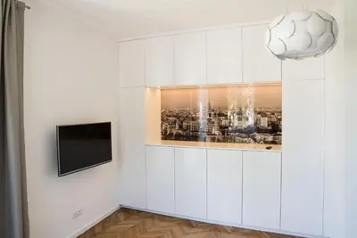 a living room with a television and a white wall at Apartment Nearto Old Town Na Ustroniu street in Kraków