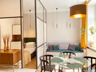a living room with a table and a couch at FAUST Apartments in the Heart of KAZIMIERZ by MINT APARTMENT in Kraków