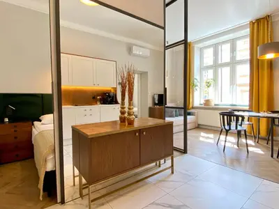 a kitchen and living room with a large mirror at FAUST Apartments in the Heart of KAZIMIERZ by MINT APARTMENT in Kraków