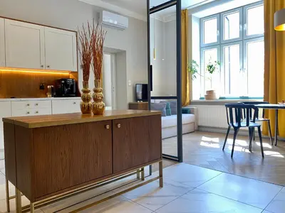 a kitchen with a wooden cabinet and a dining room at FAUST Apartments in the Heart of KAZIMIERZ by MINT APARTMENT in Kraków