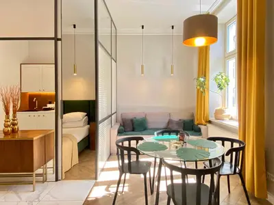 a living room with a table and chairs and a couch at FAUST Apartments in the Heart of KAZIMIERZ by MINT APARTMENT in Kraków