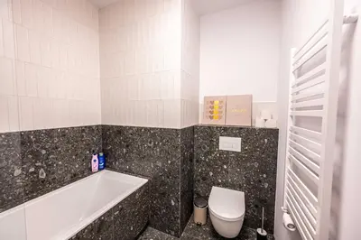 a bathroom with a tub and a sink and a shower at Trip Apartments in Kraków