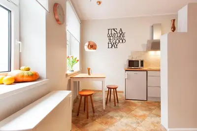 a small kitchen with a table and two stools at Mona Lisa Apartments - Kazimierz District in Kraków