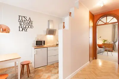 a kitchen with white cabinets and a counter top at Mona Lisa Apartments - Kazimierz District in Kraków