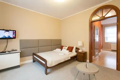 a bedroom with a bed and a flat screen tv at Mona Lisa Apartments - Kazimierz District in Kraków