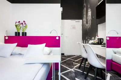 a room with a bed and a table and chairs at Best Western Plus Krakow Old Town in Kraków