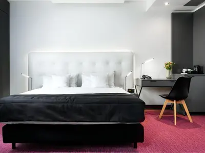 a bedroom with a large bed and a chair at Best Western Plus Krakow Old Town in Kraków