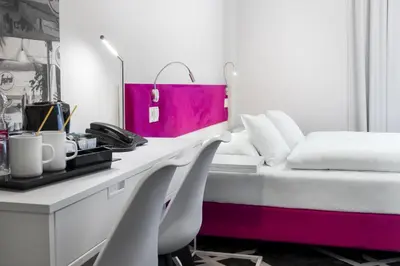 a bedroom with a bed and a desk with chairs at Best Western Plus Krakow Old Town in Kraków