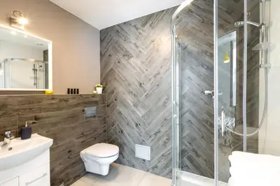 a bathroom with a shower and a toilet and a sink at Friendhouse Apartments Avenue in Kraków