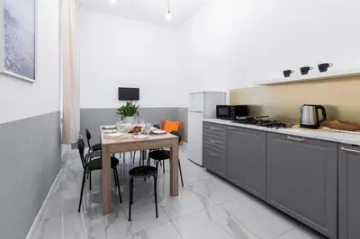 a kitchen with a table with chairs and a stove at Friendhouse Apartments Avenue in Kraków