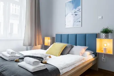 a bedroom with a bed with towels on it at Friendhouse Apartments Avenue in Kraków