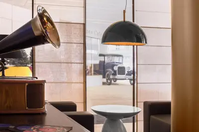 a table with a lamp and a car through a window at INX Design Hotel in Kraków