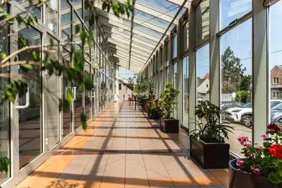 an empty corridor of a building with potted plants at Pastoral Lodge at the Sanctuary of the Divine Mercy in Kraków