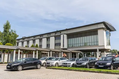 a parking lot with cars parked in front of a building at Pastoral Lodge at the Sanctuary of the Divine Mercy in Kraków