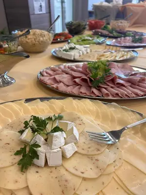 a table topped with plates of food with meat and cheese at Pastoral Lodge at the Sanctuary of the Divine Mercy in Kraków