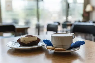 a cupcake and a cup of coffee on a table at Pastoral Lodge at the Sanctuary of the Divine Mercy in Kraków
