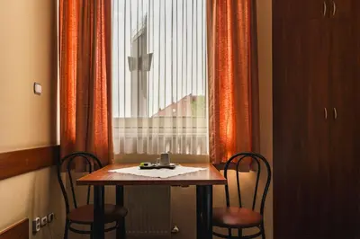 a table and two chairs in front of a window at Pastoral Lodge at the Sanctuary of the Divine Mercy in Kraków
