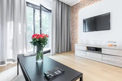 a living room with a vase of flowers on a table at CityHeaven with parking and AC in Kraków