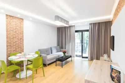 a living room with a couch and a table and chairs at CityHeaven with parking and AC in Kraków