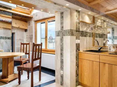 a kitchen with a table and chairs and a sink at Aparthotel Stare Miasto in Kraków