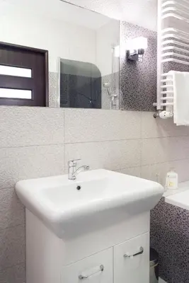 a bathroom with a white sink and a mirror at Cracow Stay Apartments in Kraków