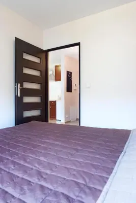 a bedroom with a purple bed and a door at Cracow Stay Apartments in Kraków