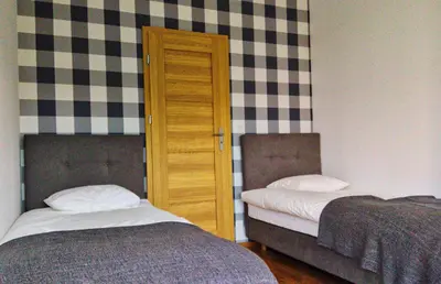a bedroom with two beds and a door in it at JT Apartments/Dworska in Kraków