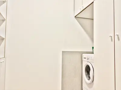 a white laundry room with a washer and dryer at JT Apartments/Dworska in Kraków