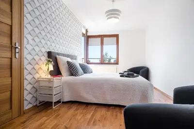 a white bedroom with a bed and a window at JT Apartments/Dworska in Kraków