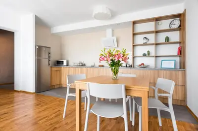a kitchen and dining room with a wooden table and chairs at JT Apartments/Dworska in Kraków