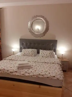 a bedroom with a large bed with a large mirror at Podzamcze in Rożnów
