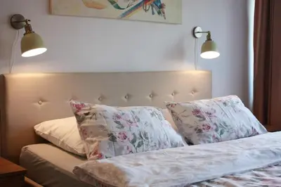 a bedroom with a bed with two pillows and two lights at Podzamcze in Rożnów