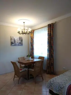 a dining room with a table and chairs and a window at Podzamcze in Rożnów