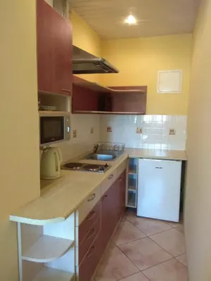 a kitchen with brown cabinets and a white refrigerator at Podzamcze in Rożnów