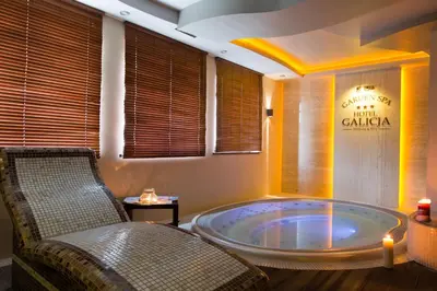 a jacuzzi tub in a room with a chair at Hotel Galicja Superior Wellness & Spa in Oświęcim
