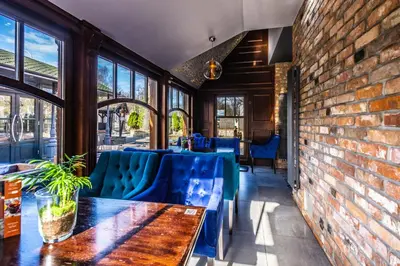 a restaurant with blue chairs and a brick wall at Hotel Galicja Superior Wellness & Spa in Oświęcim