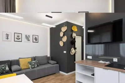 a living room with a couch and a flat screen tv at Słowackiego 11B - cozy studio by Homeprime in Kraków