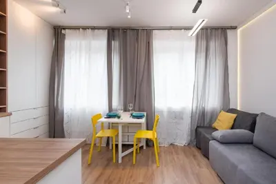 a living room with a couch and a table and yellow chairs at Słowackiego 11B - cozy studio by Homeprime in Kraków