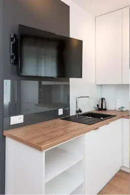 a white kitchen with a sink and a microwave at Słowackiego 11B - cozy studio by Homeprime in Kraków