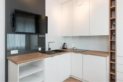 a kitchen with white cabinets and a sink at Słowackiego 11B - cozy studio by Homeprime in Kraków