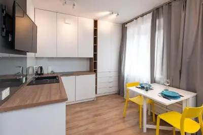 a kitchen with a table and yellow chairs in a room at Słowackiego 11B - cozy studio by Homeprime in Kraków