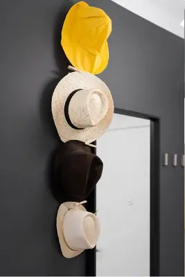 a group of hats hanging on a wall at Słowackiego 11B - cozy studio by Homeprime in Kraków