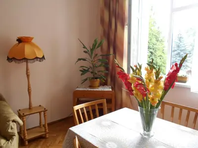 a vase of flowers on a table in a room at Apartament Krakowski Styl in Kraków