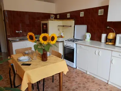 a kitchen with a table with sunflowers on it at Apartament Krakowski Styl in Kraków