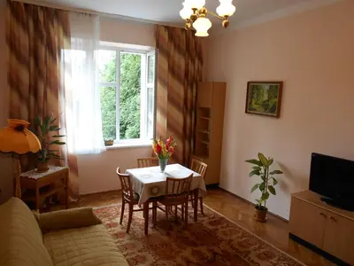 a living room with a table and a window at Apartament Krakowski Styl in Kraków