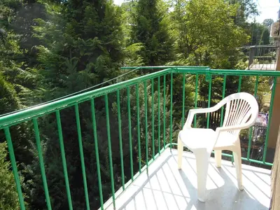 a white chair sitting on a balcony at Apartament Krakowski Styl in Kraków